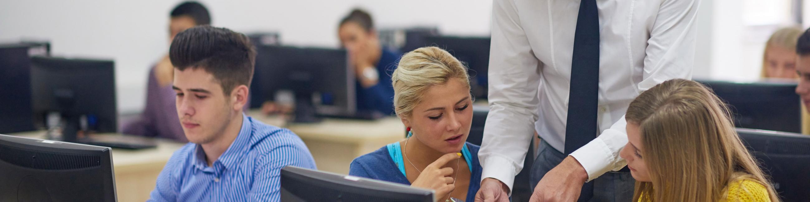Teacher working with three students in the lab.