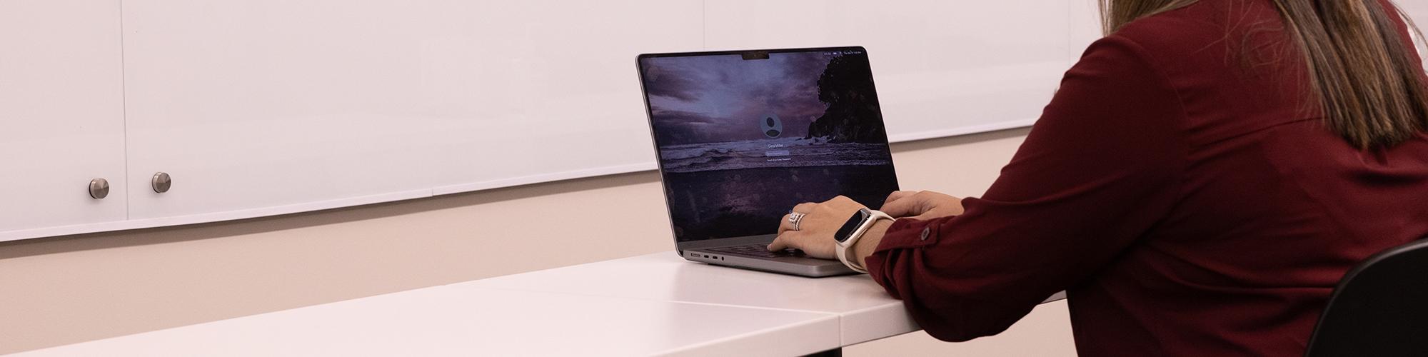 Researcher typing on laptop