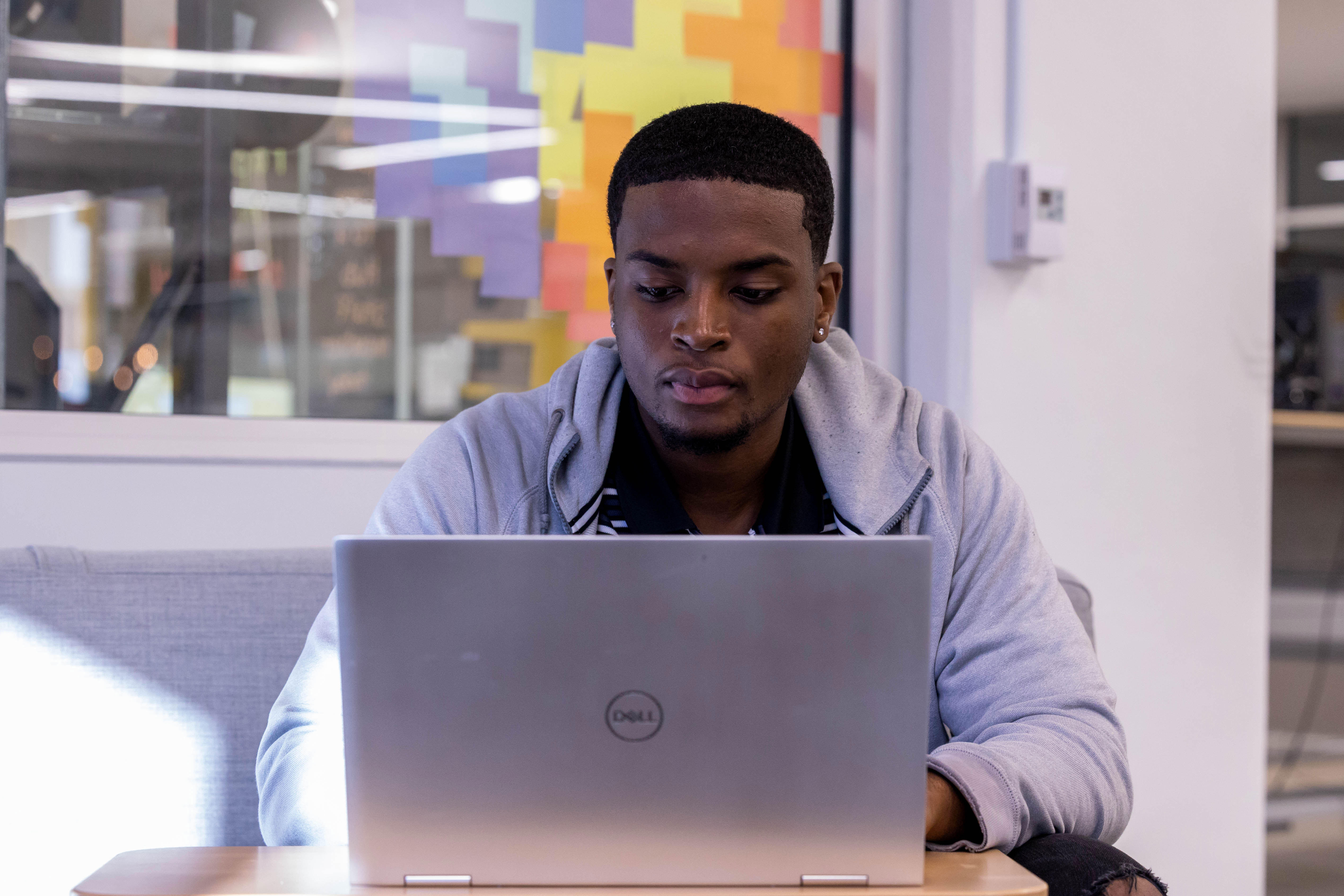 Male sitting inside working on his laptop.