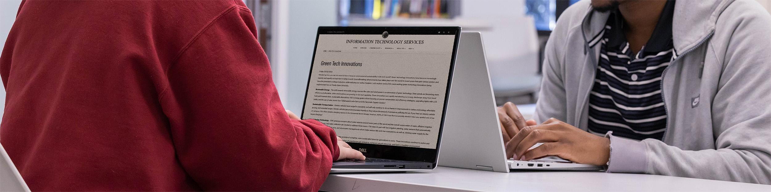 Student reading ITS news article on laptop