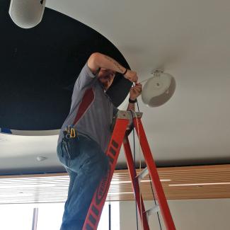 ITS tech installing speakers in new EOAS building
